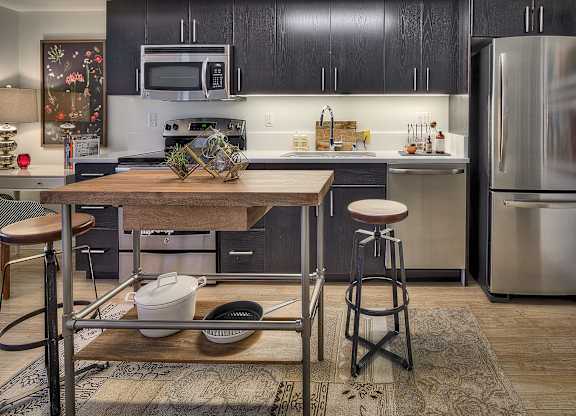 a kitchen with stainless steel appliances and a wooden table