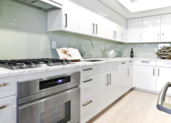 a white kitchen with stainless steel appliances and white cabinets