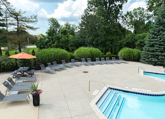 A pool with a slide and sun loungers.