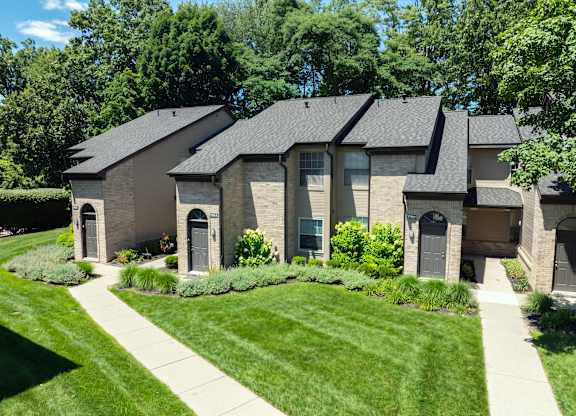 A house with a grey roof and a green lawn in front.
