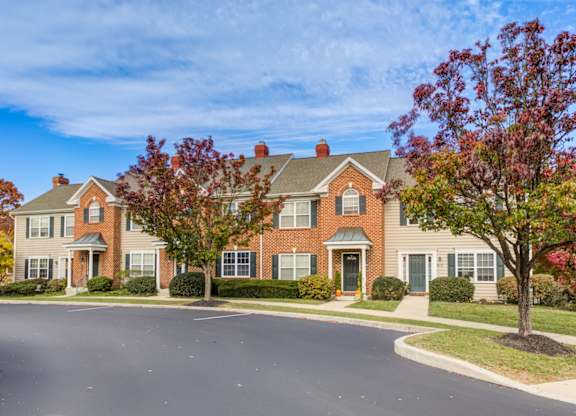 A large brick house with a green lawn in front at Highlands at Warwick Apartments, Lilitz, PA