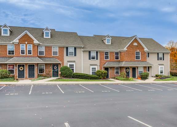 A large brick building with a parking lot in front at Highlands at Warwick Apartments, Lilitz, PA 17543