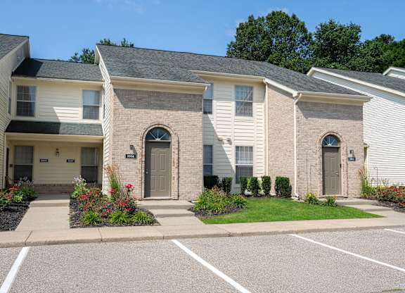 A row of houses with a parking lot in front.