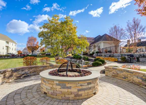 A circular brick fountain is the centerpiece of a landscaped garden at Meridian West Shore, Mechanicsburg, 17055