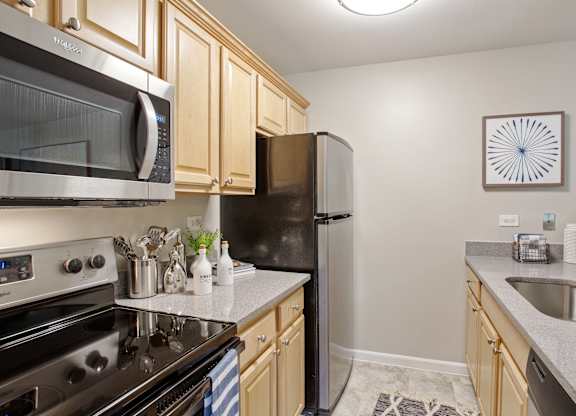 Kitchen with a black stove at fifty9 Grove Apartments, Naperville, 60563