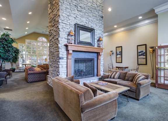 A living room with a stone fireplace and a couch at The Crest at Elm Tree, Mount Joy, PA 17552