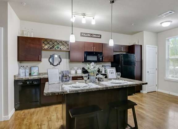 Modern kitchen with granite countertops and island at Reserve at Romeoville, Romeoville, IL