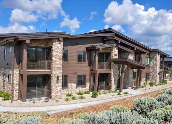 A modern house with a brown exterior and stone pillars.