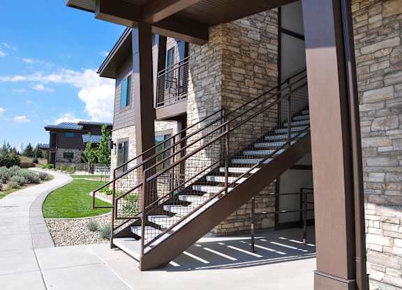 A staircase with a metal railing leads up to a building.