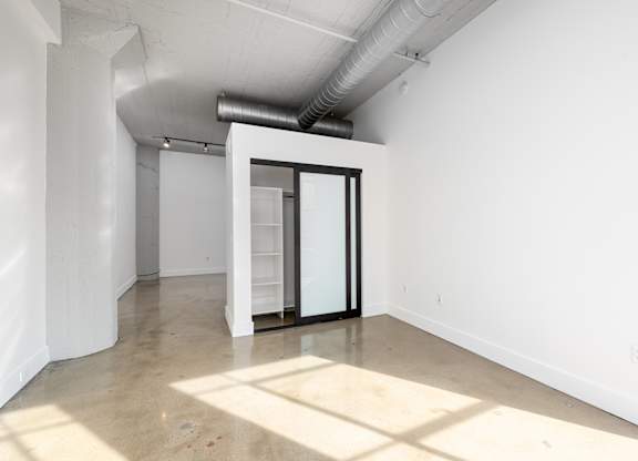 A room with a white wall and a door with a glass window.