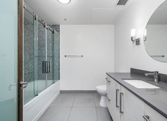 A modern bathroom with a walk-in shower and a toilet.