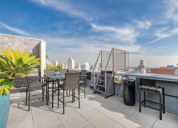 A patio with a table and chairs overlooking a cityscape.