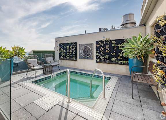 A small pool on a patio with a glass railing.