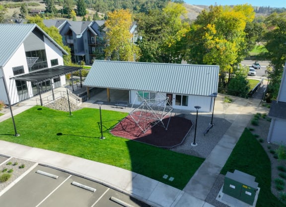 an aerial view of a swing set in front of a house