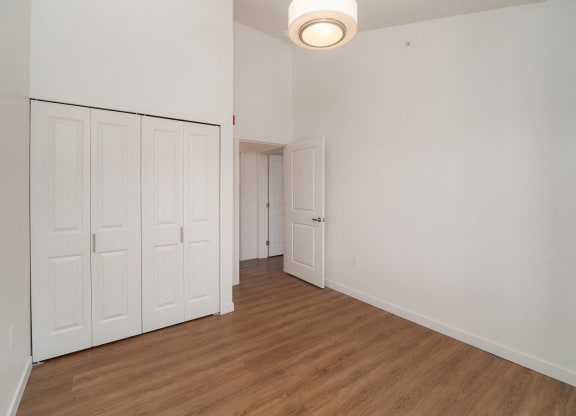 an empty living room with white walls and wood flooring