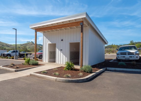 a parking lot with a white building with a car parked in it