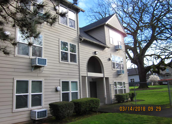 the outside of a house with a lawn and trees