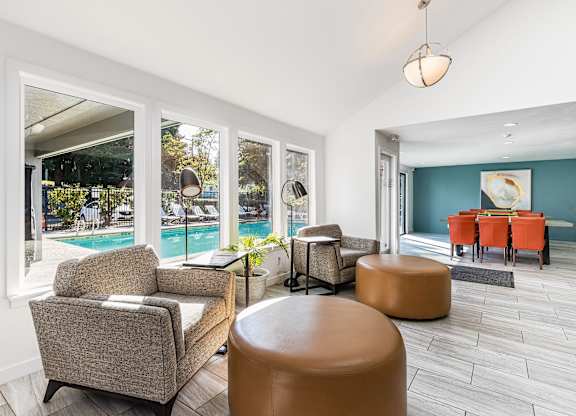 A living room with a pool outside the window.