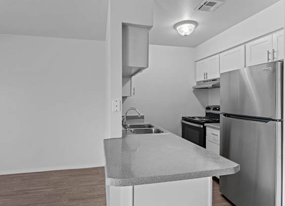 A kitchen with a stainless steel refrigerator and a countertop.