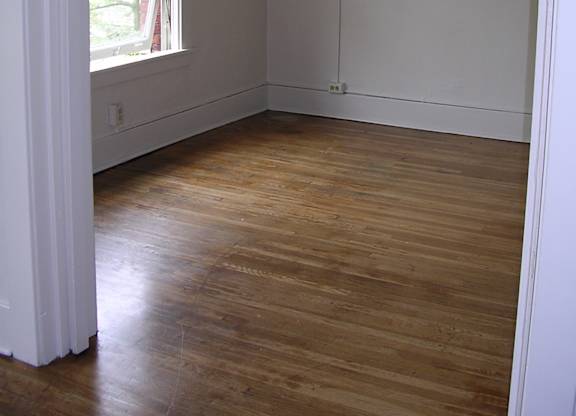 A room with a window and wooden floors.
