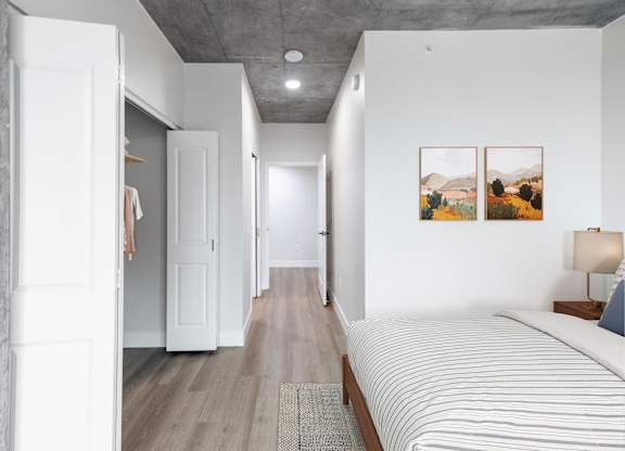 A long hallway with a bed on the right side.
