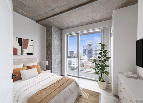 A bedroom with a large bed and a view of the city.