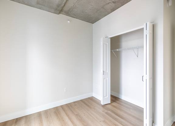 A room with a white door and a white closet.