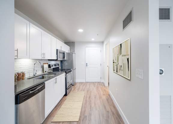 A modern kitchen with stainless steel appliances and white cabinets.