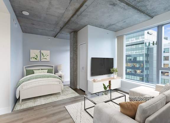 A bedroom with a bed, a couch, and a television.