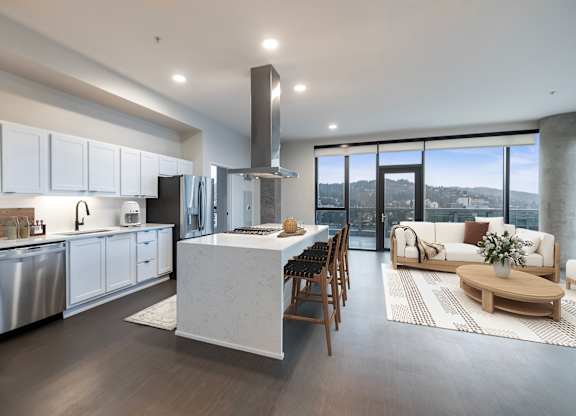 A modern kitchen with a large island and a view of the city.
