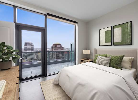 A bedroom with a large bed and a view of the city.