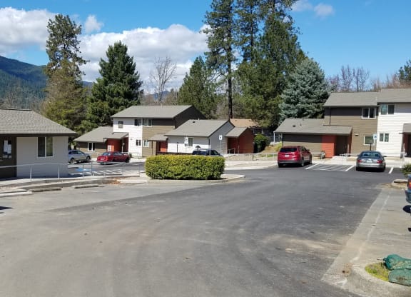 a neighborhood with houses and cars parked in a parking lot