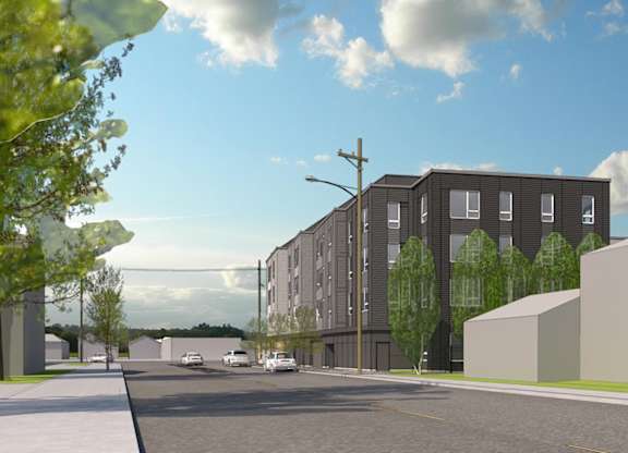 A street view of a residential area with apartment buildings and parked cars.