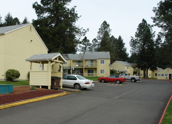 a parking lot with cars in front of apartment buildings