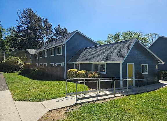 A blue house with a yellow door and a metal railing.