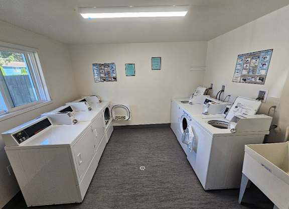 A clean, well-organized laundry room with washers and dryers.