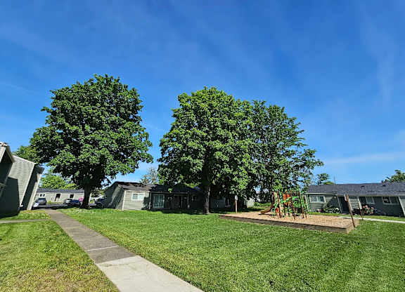 A sunny day in a residential area with houses and green trees.