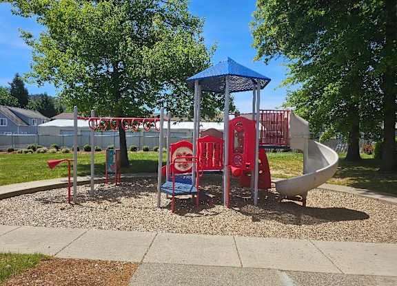 A playground with a blue canopy and red and white slides.
