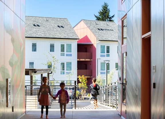 A woman and a child are walking down a hallway.