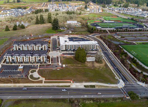 An aerial view of a large building with a parking lot in front of it.