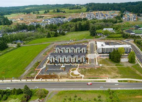An aerial view of a large building complex with a parking lot in front.