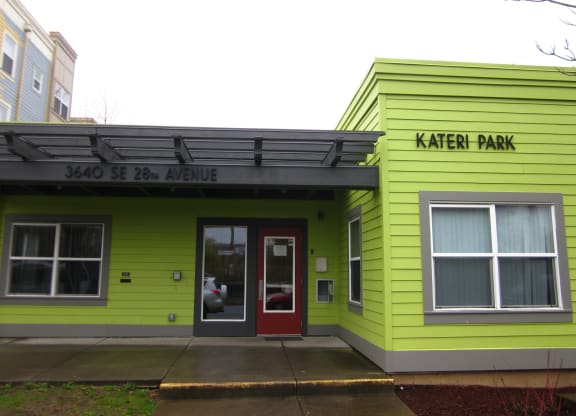 the building is painted yellow and green and has a red door