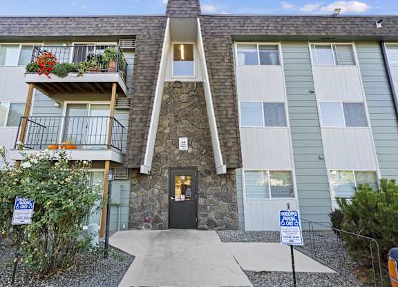 the front of an apartment building with a walkway and a balcony