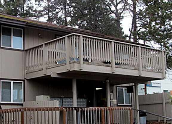 A house with a deck and a fence.