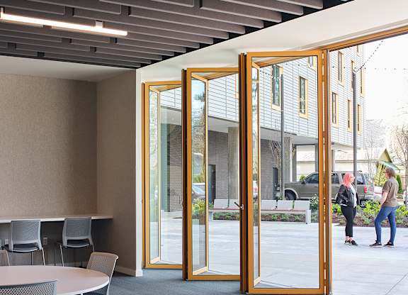 A conference room with a table and chairs and a glass door leading outside.