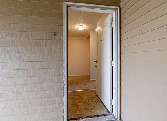 A white door is open to a hallway.