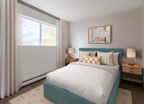 A bedroom with a bed, nightstands, and a window.