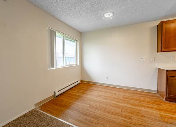 A room with a window and a wooden floor.