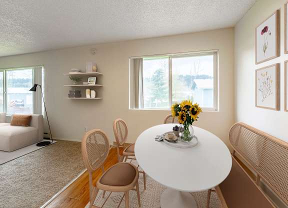 A dining room with a white table and chairs.