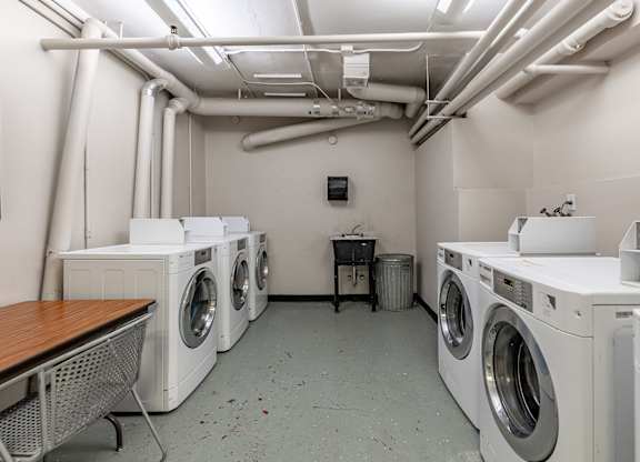 A laundry room with washing machines and a table.